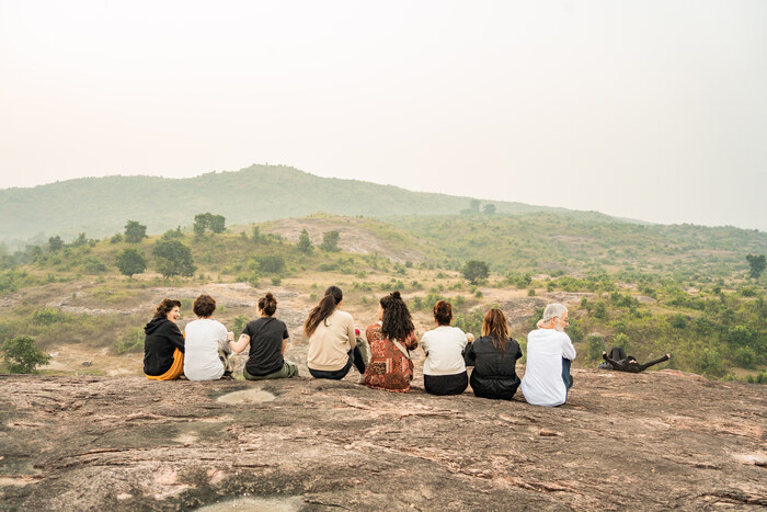 Yogabeoefenaars zitten samen op een rots met uitzicht over het Indiase platteland. Yogabeoefenaars zitten samen op een rots met uitzicht over het Indiase platteland.