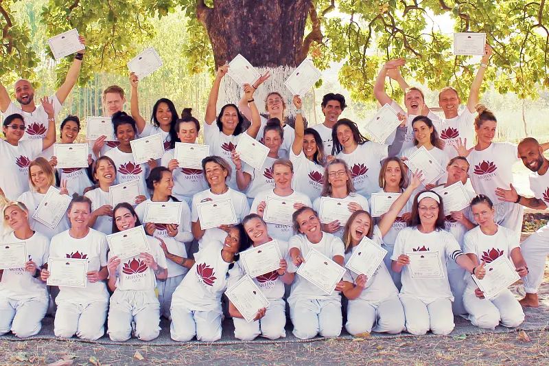 Afgestudeerde cursisten tonen hun 200-uur yogadocentcertificaten na Arhanta Yoga-opleiding